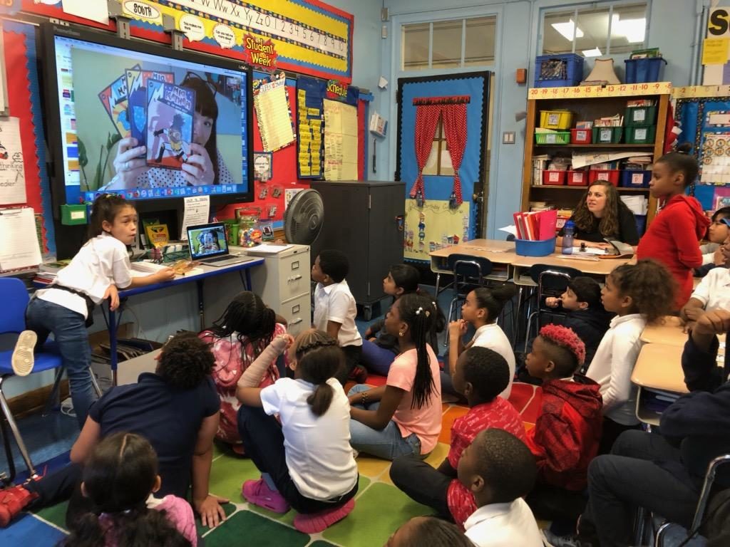 Students interacting with author via video chat